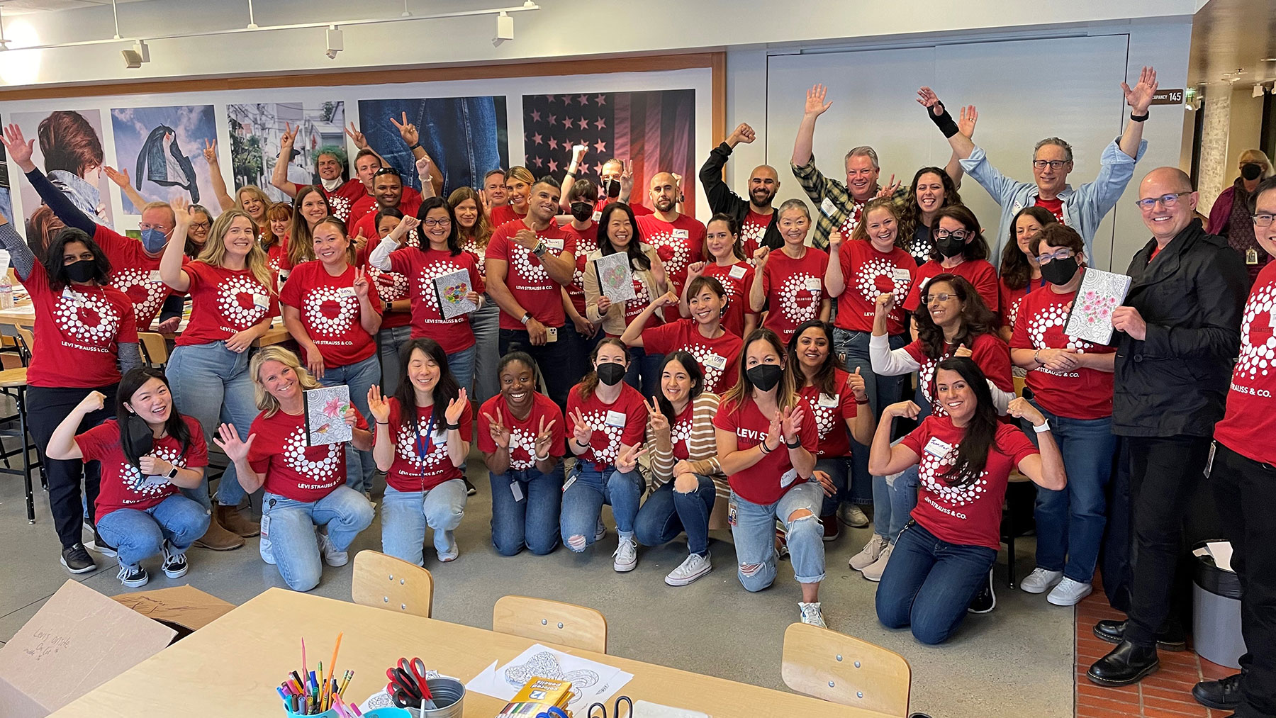 A group of LS&Co. employee volunteers pose for a photo in a classroom wearing their red Community Day t-shirts