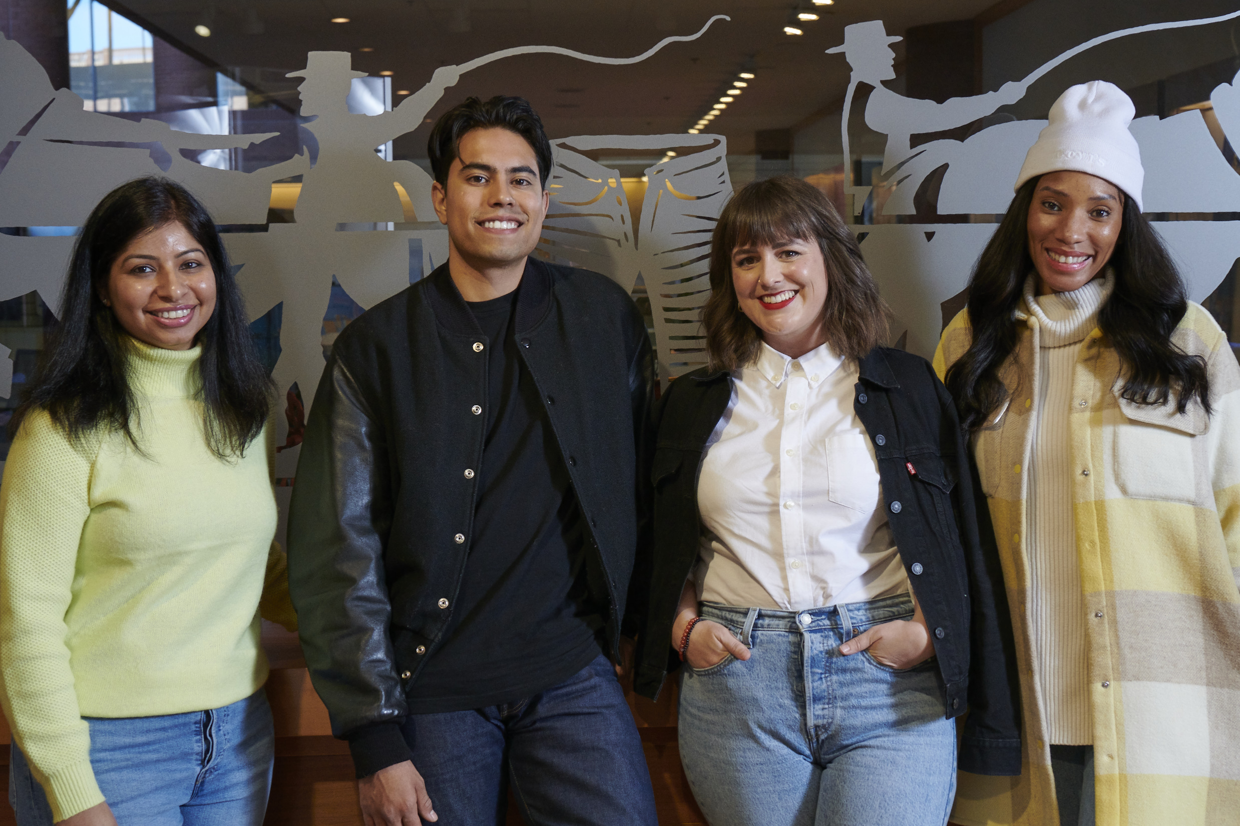A group of four LS&Co. employees stand next to each other and smile at the camera